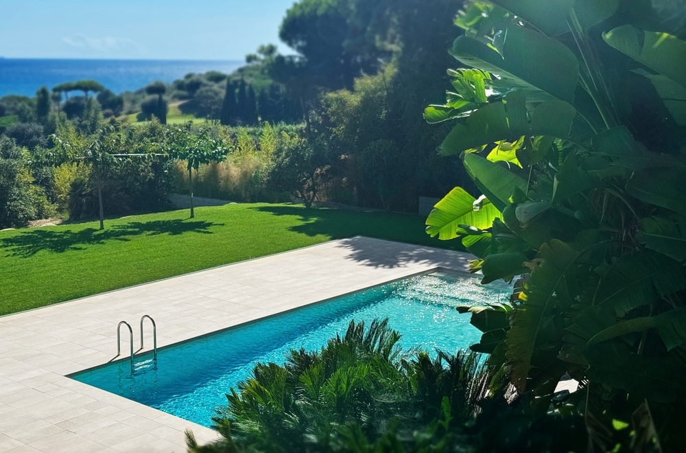 Piscine et jardin méditerranéen: Cyprès, agave et terrasse bois. Piscine contemporaine à terrasse bois, bordée de cyprès et d'agaves. Vue panoramique sur la forêt méditerranéenne et pergola.